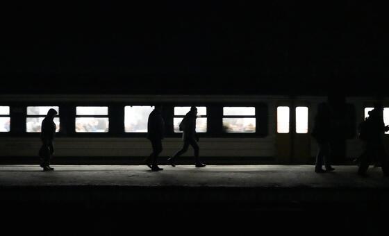 Les voyageurs se déplacent dans une gare pendant une panne d'électricité, illustrant comment les perturbations de l'approvisionnement en électricité peuvent rapidement affecter les transports, les communications et la vie quotidienne.